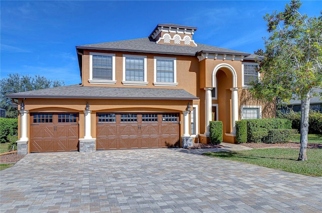 view of front of property with a garage, decorative driveway, and stucco siding