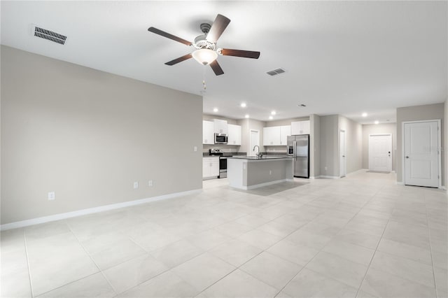 unfurnished living room with light tile patterned floors, ceiling fan, and sink