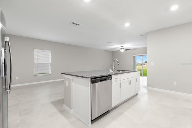 kitchen featuring white cabinetry, sink, dark stone counters, a kitchen island with sink, and appliances with stainless steel finishes