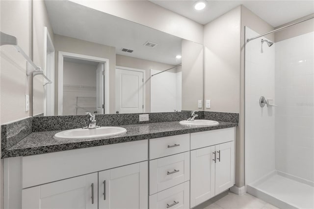 bathroom featuring tile patterned floors, a shower, and vanity