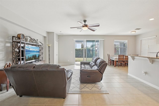 living room with ceiling fan and light tile patterned flooring