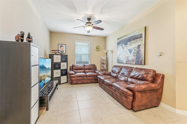 living room with a textured ceiling, ceiling fan, and light tile patterned flooring