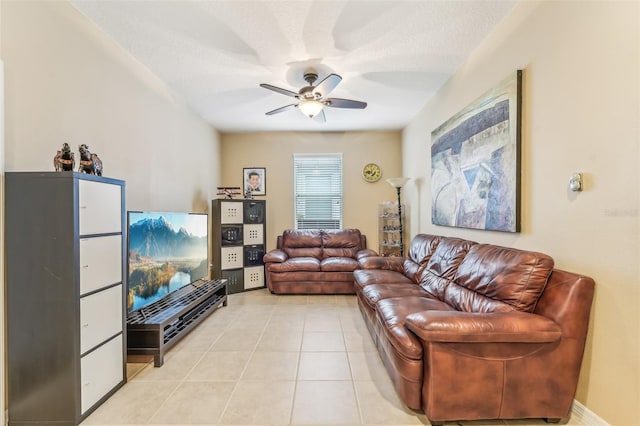 living room with ceiling fan, light tile patterned floors, and a textured ceiling