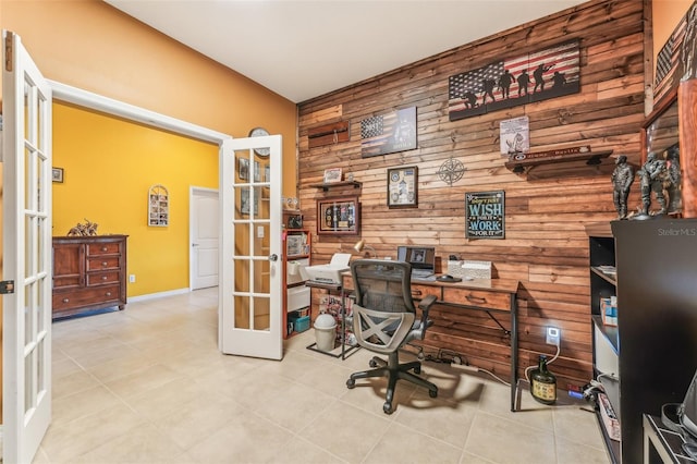 office area featuring light tile patterned flooring, french doors, and wood walls