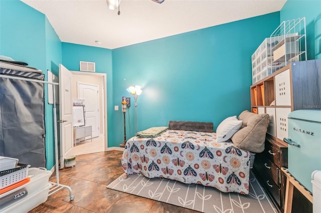 bedroom with ceiling fan and refrigerator