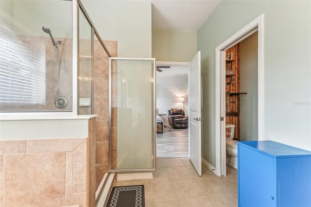 bathroom featuring ceiling fan, tile patterned flooring, an enclosed shower, and toilet