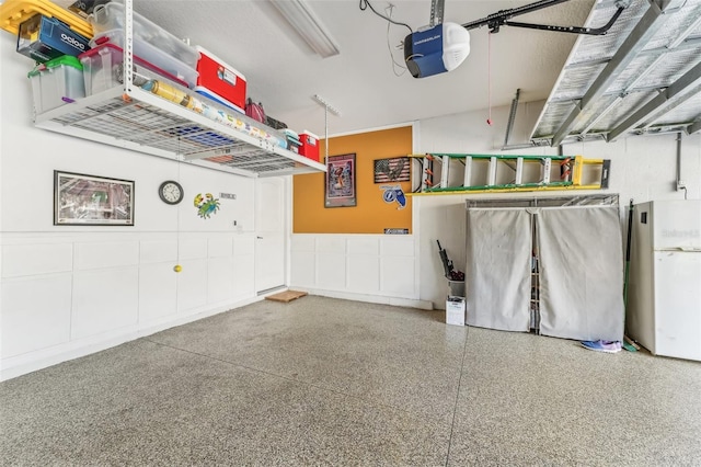 garage featuring white fridge and a garage door opener