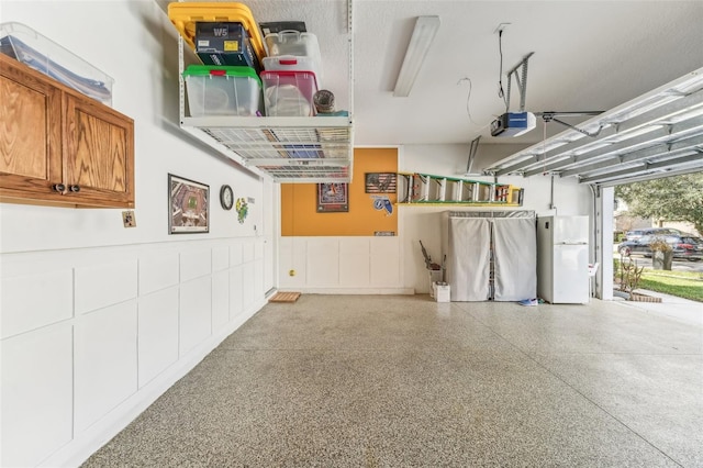 garage featuring a garage door opener and white refrigerator