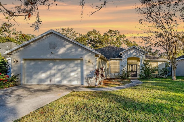 single story home featuring a yard and a garage