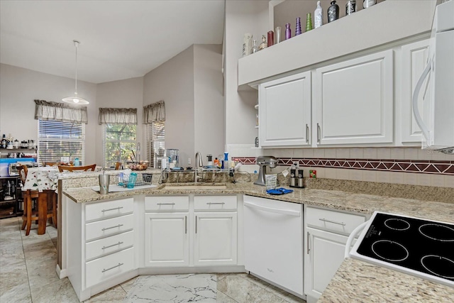 kitchen featuring kitchen peninsula, white appliances, sink, white cabinets, and hanging light fixtures