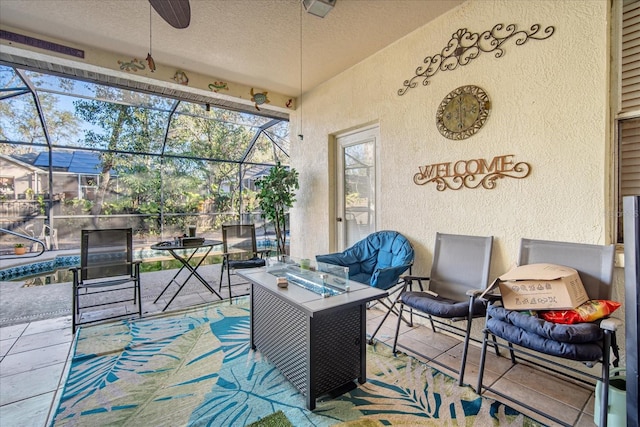 view of patio with a lanai, ceiling fan, and an outdoor fire pit