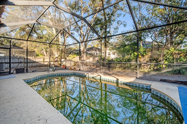 view of pool featuring glass enclosure and a patio area