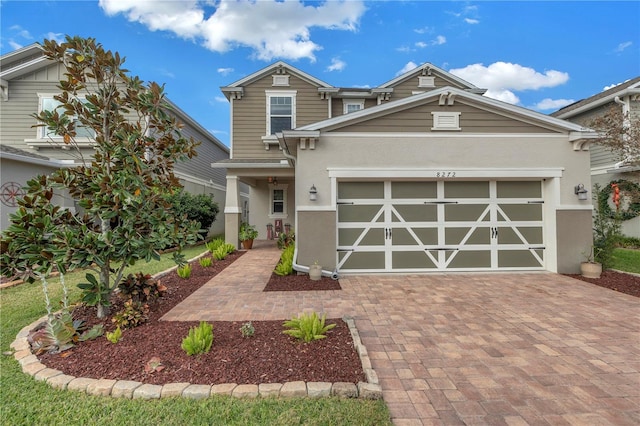 view of front facade with a garage, decorative driveway, and stucco siding