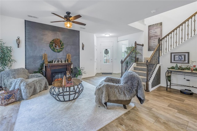 living room featuring light hardwood / wood-style flooring and ceiling fan