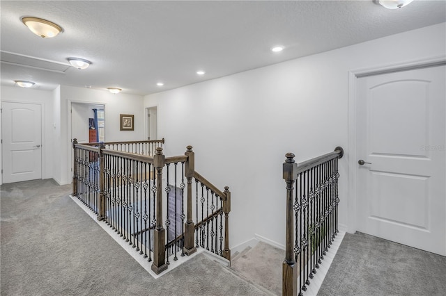 hallway featuring light carpet and a textured ceiling