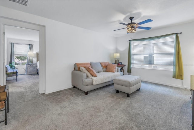 carpeted living room with ceiling fan