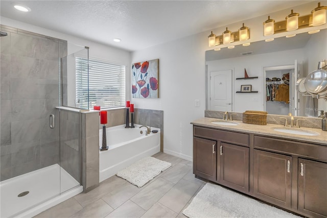 bathroom with tile patterned floors, vanity, a textured ceiling, and shower with separate bathtub