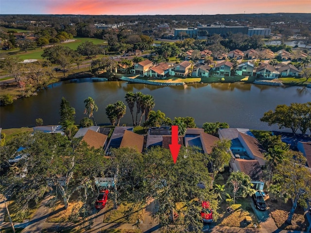 aerial view at dusk featuring a water view