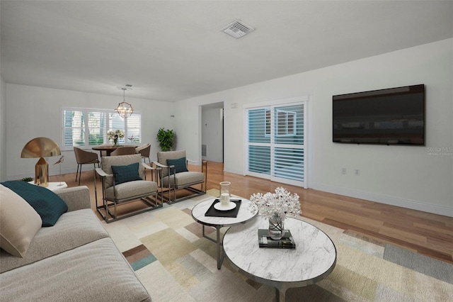 living room featuring an inviting chandelier and light hardwood / wood-style flooring