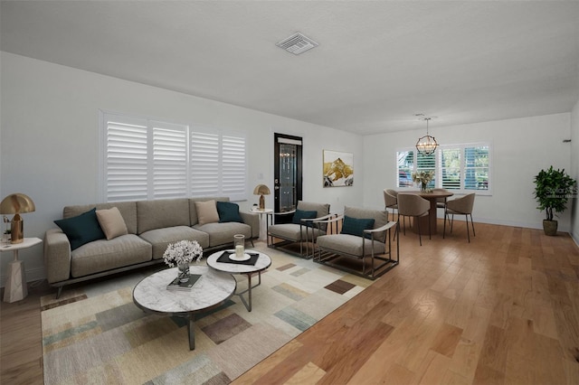 living room with a notable chandelier and light hardwood / wood-style floors