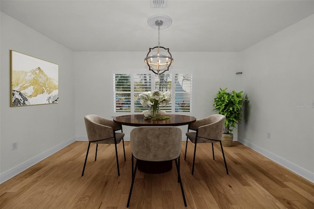 dining area featuring an inviting chandelier and light wood-type flooring