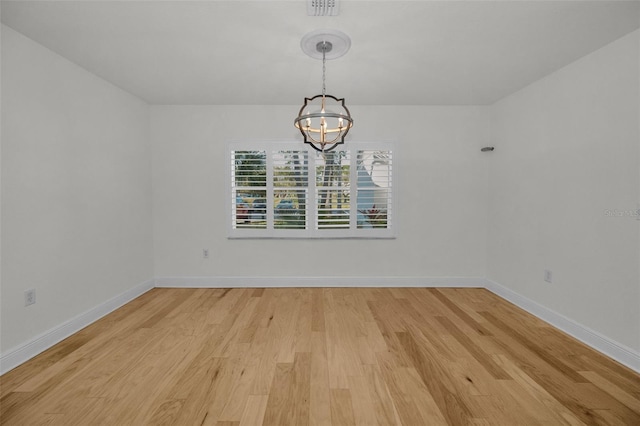 unfurnished dining area with a chandelier and light hardwood / wood-style floors