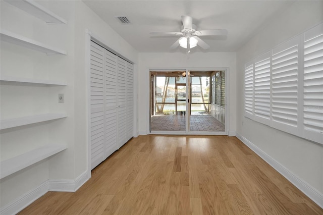 empty room featuring ceiling fan, built in features, and light hardwood / wood-style floors