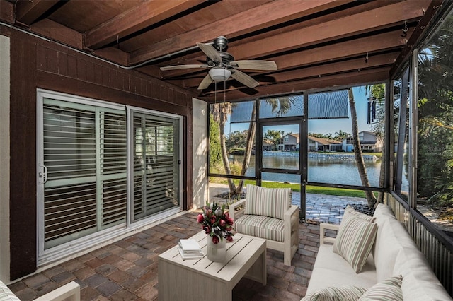 unfurnished sunroom with ceiling fan, a water view, a wealth of natural light, and beam ceiling