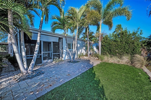 view of yard with a sunroom and a patio