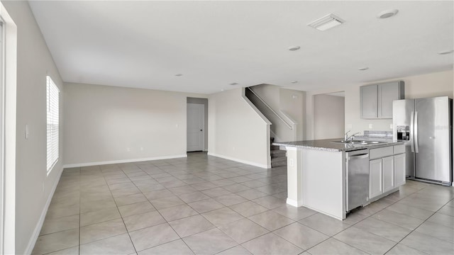 kitchen featuring a kitchen island with sink, sink, light tile patterned floors, and stainless steel appliances