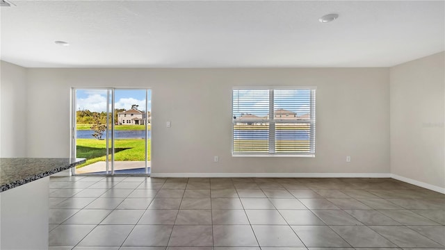 spare room featuring tile patterned floors and a wealth of natural light