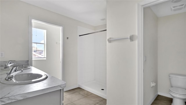 bathroom featuring tile patterned flooring, a shower, vanity, and toilet