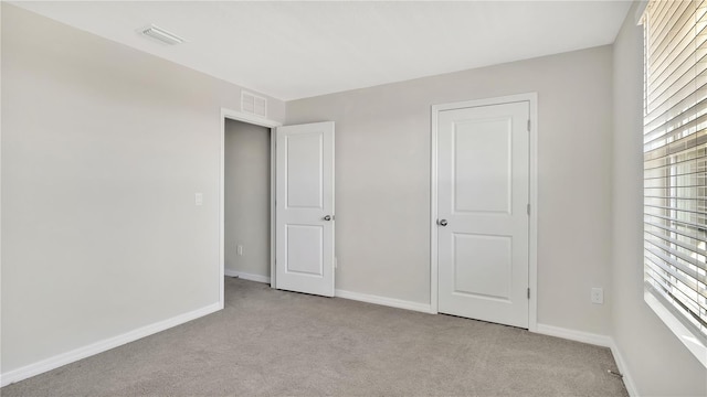 unfurnished bedroom featuring light carpet