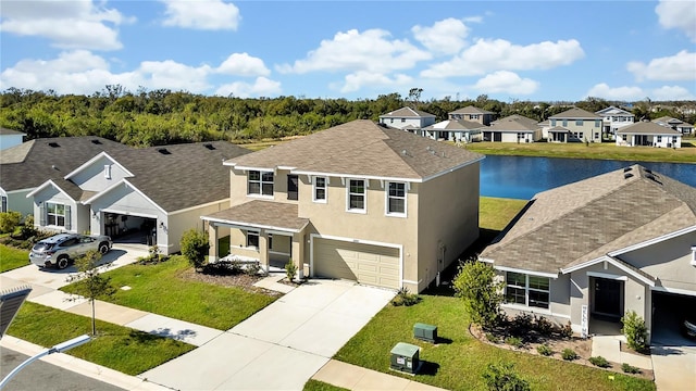 view of front of house with a water view, a front yard, and a garage