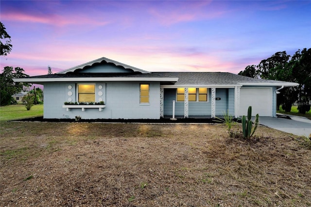 ranch-style house with driveway, concrete block siding, a shingled roof, and a garage