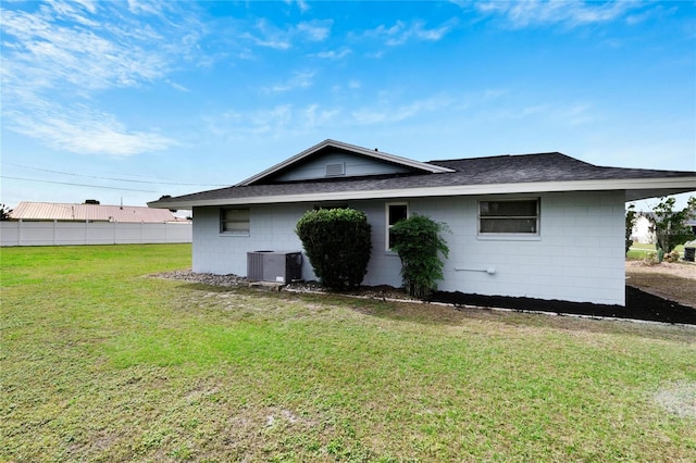 back of house with cooling unit and a yard