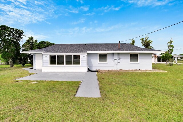 1201 Harkness Way, Sun City Center, FL 33573 - rear view of house with a lawn, a patio, and a shingled roof