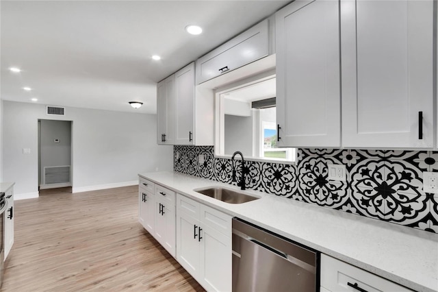 kitchen featuring dishwasher, white cabinets, light wood-type flooring, and sink