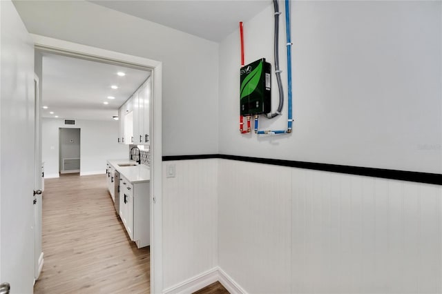 hall with light wood-type flooring and sink