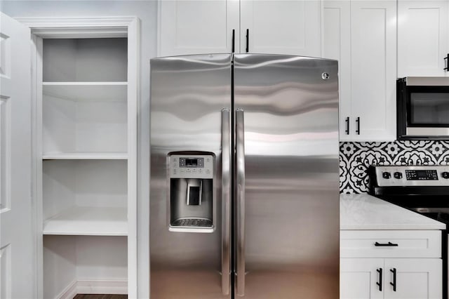 kitchen featuring decorative backsplash, white cabinetry, and appliances with stainless steel finishes