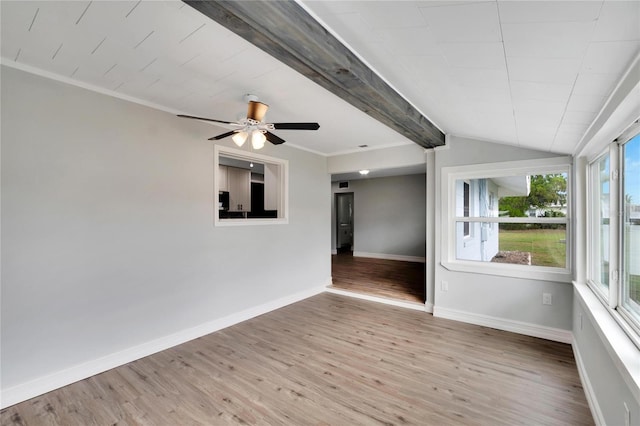 empty room featuring ceiling fan, crown molding, lofted ceiling with beams, and light wood-type flooring