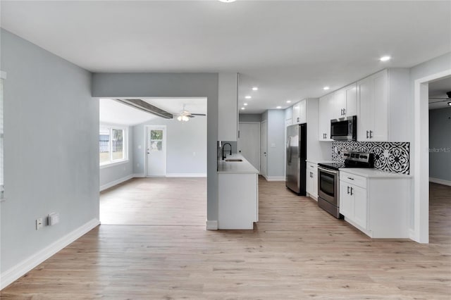 kitchen featuring a sink, open floor plan, baseboards, ceiling fan, and appliances with stainless steel finishes