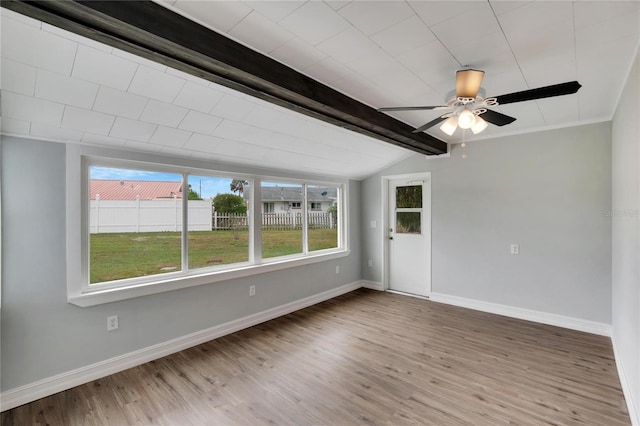 unfurnished room with wood finished floors, vaulted ceiling with beams, baseboards, and ceiling fan