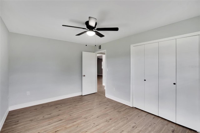 unfurnished bedroom with a closet, light wood-style floors, ceiling fan, baseboards, and visible vents