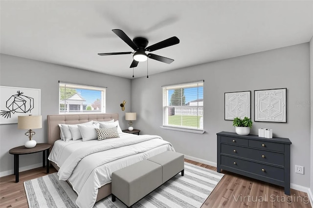 bedroom with wood finished floors, baseboards, and ceiling fan