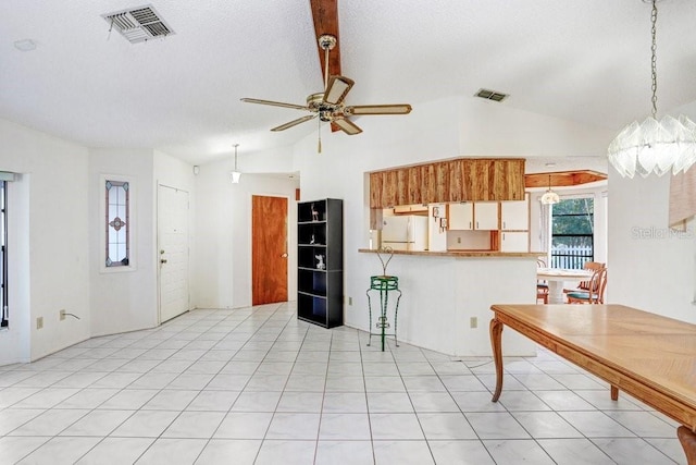 kitchen featuring ceiling fan, kitchen peninsula, white fridge, decorative light fixtures, and lofted ceiling