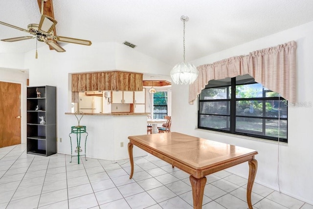 tiled dining space with ceiling fan, plenty of natural light, and lofted ceiling