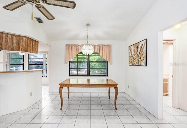 dining area with ceiling fan with notable chandelier, plenty of natural light, and lofted ceiling