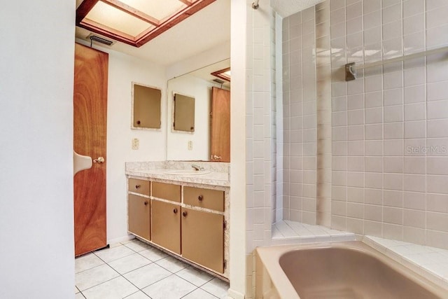 bathroom with tile patterned floors, a tub to relax in, and vanity