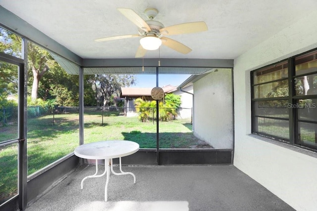 unfurnished sunroom featuring ceiling fan